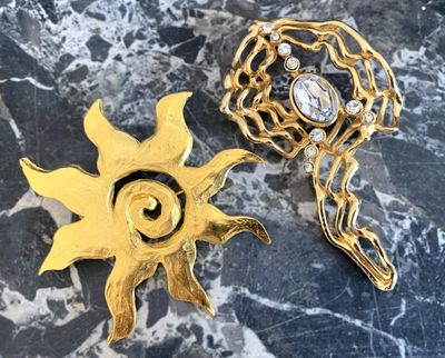 Deux importantes broches en métal doré, l'une à strass, l'au…