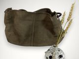 brown leather purse with a flower in it and a vase of wheat