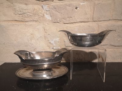 un bol en argent et une soucoupe en argent posés sur une table noire