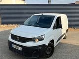 une camionnette blanche garée sur un parking près d'une clôture