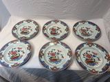 six plates with floral designs on them sitting on a white cloth