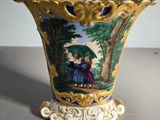un vase sur lequel figurent deux enfants tenant un parapluie