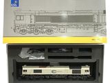 une boîte contenant un train miniature, posée sur une surface blanche