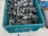 a blue basket full of metal parts on a table