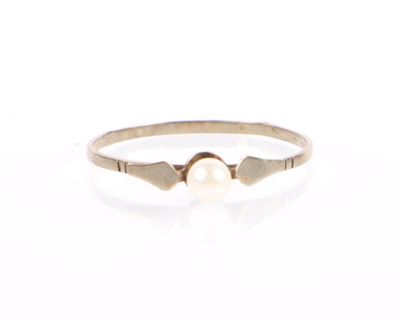 gros plan d'une bague en perle sur une surface blanche
