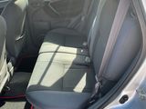 the back seats of a silver car with red trims and a black floor mat