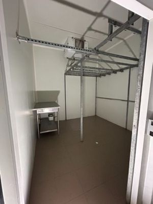une pièce équipée d'une table et d'un réfrigérateur