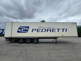 un semi-remorque blanc garé sur un parking sous un ciel nuageux