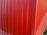 a red container sitting on the side of the road