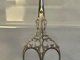 a pair of scissors sitting on a table in front of a glass case