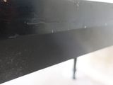 a close up view of a metal table with a black top