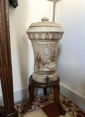 un vase blanc posé sur un socle en bois dans une pièce