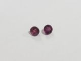 a pair of pink tourmaline gems on a white surface