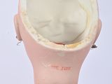 a pink doll with a white face and a pink body
