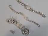 three pieces of silver jewelry on a white surface