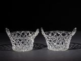 pair of crystal bowls with handles on a black surface