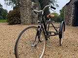 a bike that is parked in the gravel near a building