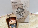 a small figurine of a boy sitting in a box