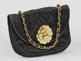 un sac à main noir matelassé orné d'une fleur dorée