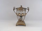 a silver and glass vase with spoons on it