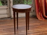 une petite table posée sur un parquet, devant une fenêtre