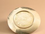 an image of a silver plate with a medallion on it
