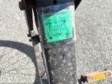 un gros plan d'un vélo sur lequel est collé un autocollant vert