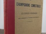 un vieux livre posé sur une table à côté d'un mur blanc