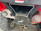 a close up of a red atv with a big tire
