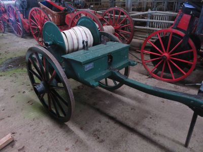 un wagon vert avec une roue blanche, suivi d'un wagon rouge