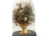 a glass dome with flowers inside of it on a table