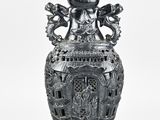 a black vase with a dragon on it on a white background