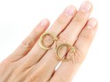 someone is holding a pair of gold rings in their hand