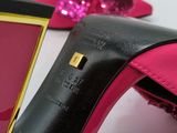 pair of pink and black high heeled shoes with a gold buckle