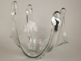 a clear glass vase with a silver handle on a table