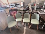 Plusieurs chaises sont alignées dans une pièce où se trouvent de nombreux meubles.