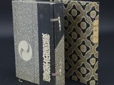 un vieux livre à la couverture noire et à la reliure dorée et noire