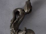 une figurine en argent représentant un homme tenant un champignon