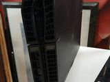 a black computer sitting on top of a table in front of a red wall