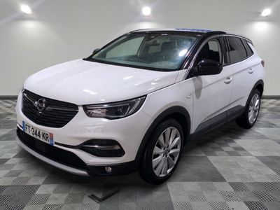 the white opel suv is parked in a large room