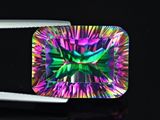 a close up of a square cut rainbow colored diamond on a black surface