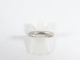 gros plan d'une bague en argent sur une surface blanche