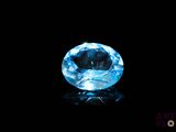 a close up of a blue diamond on a black surface