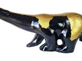 a black and gold dinosaur figurine on a white background