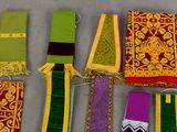 many different colors of scarves laid out on a table