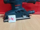 un gros plan d'une ponceuse orbitale Bosch posée sur une table