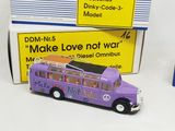 un petit bus jouet violet posé à côté d'une boîte