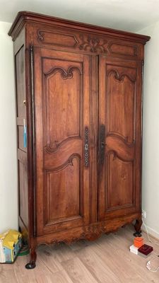 une grande armoire en bois dans le coin d'une pièce