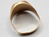 a close up of a gold ring on a white surface
