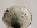 a close up of a white vase with a brown rim